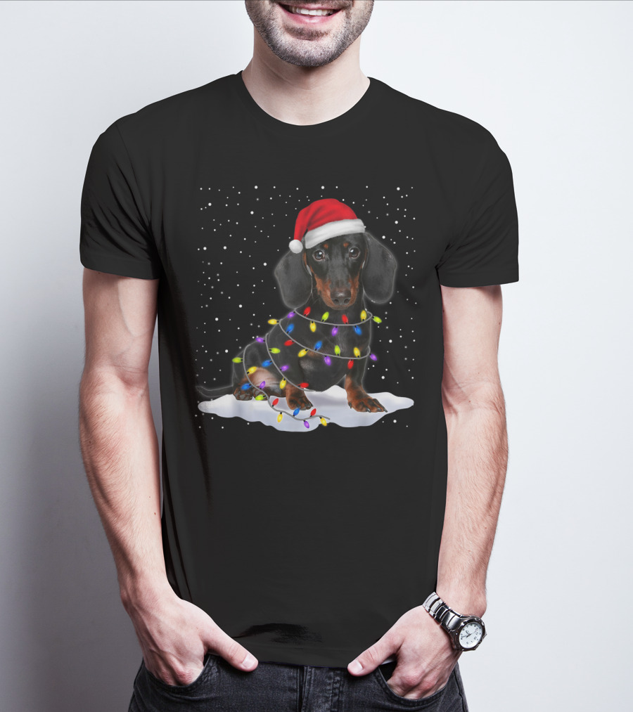 Dachshund Santa Hat Wrapped In Christmas Tree Lights In Snow With Falling Snowflakes T-Shirt