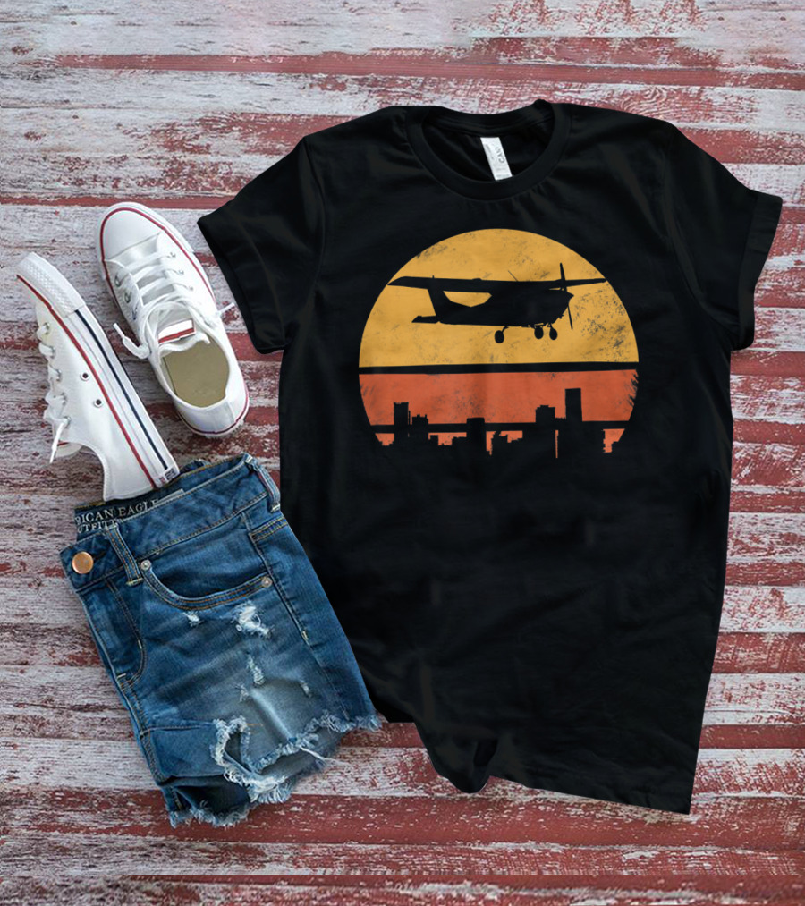 Retro Pilot C172 Flying Silhouette Over Sunset Cityscape T-Shirt