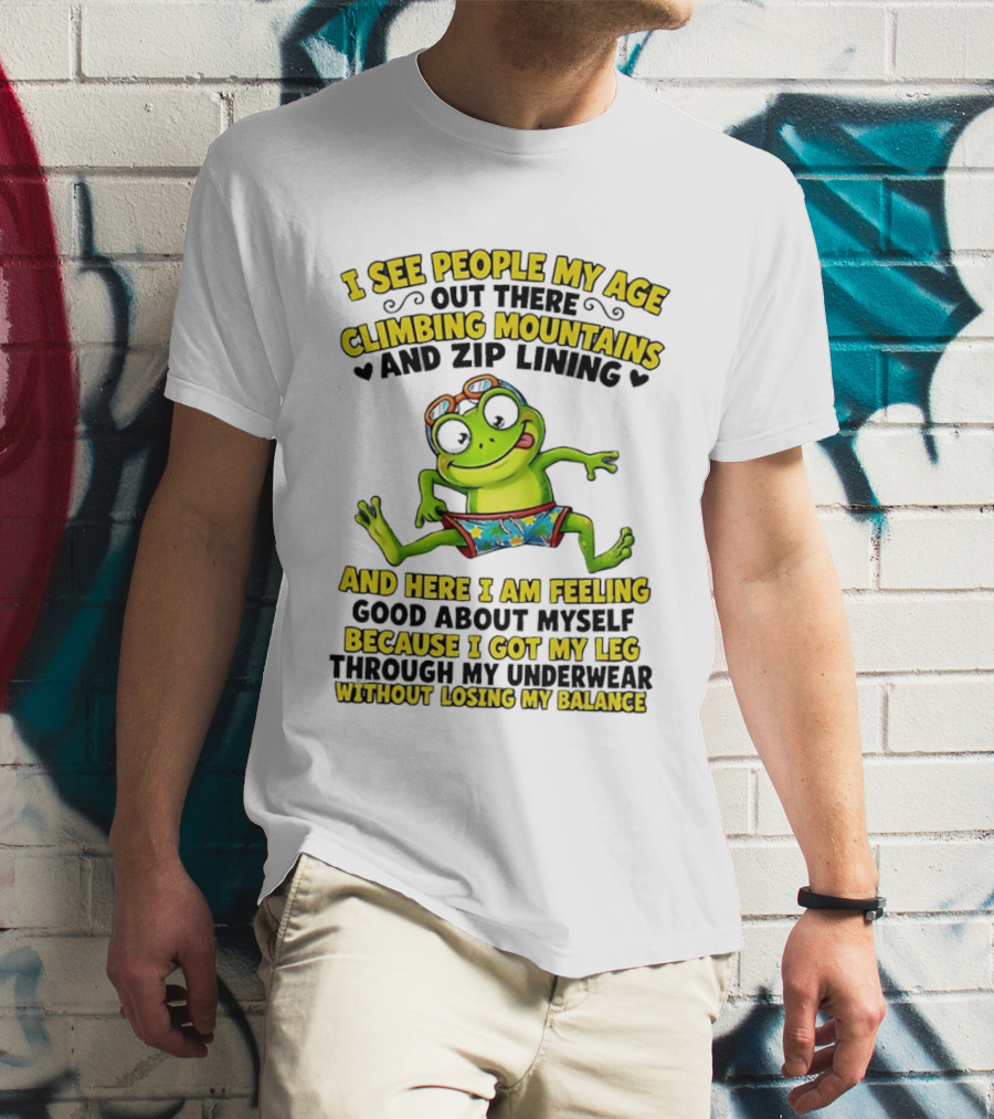I See People My Age Climbing Mountains And Zip Lining Cartoon Frog Feeling Good Without Losing Balance T-Shirt
